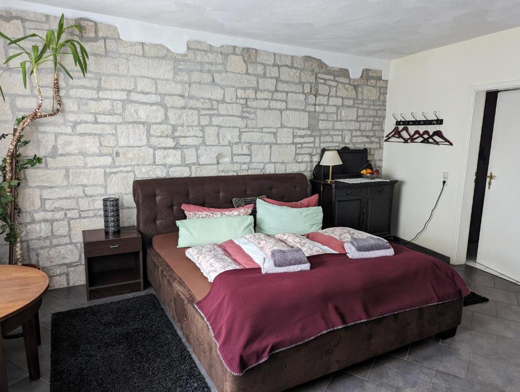 a bed in a room with a brick wall at Gasthaus alt Freyburg in Freyburg