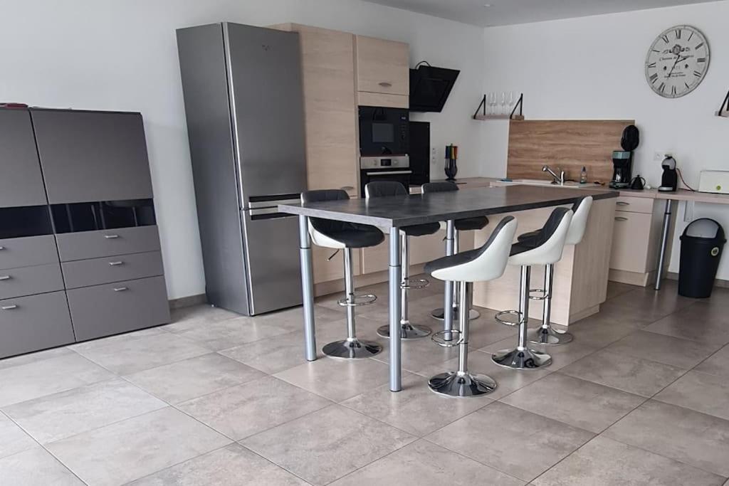 una cucina con tavolo, alcune sedie e frigorifero di super appartement 100m2 a Ribeauvillé