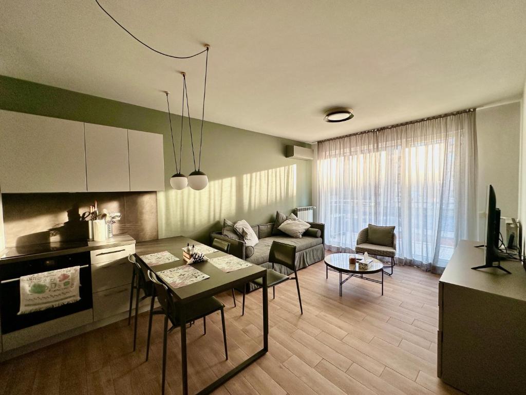 7th Sense boutique apartments في صوفيا: مطبخ وغرفة معيشة مع طاولة وأريكة