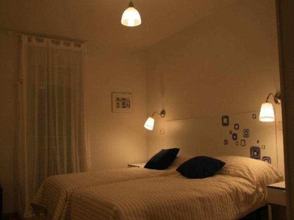 a bedroom with a bed with two pillows on it at Hochwertige Ferienwohnung im Grüngürtel der Stadt in Madrid