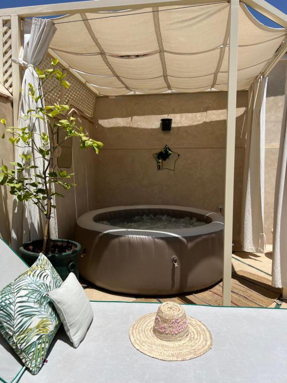 a hot tub under a tent with a table at Dar Vevé - Design, style & relax in Dar el Bacha in Marrakesh
