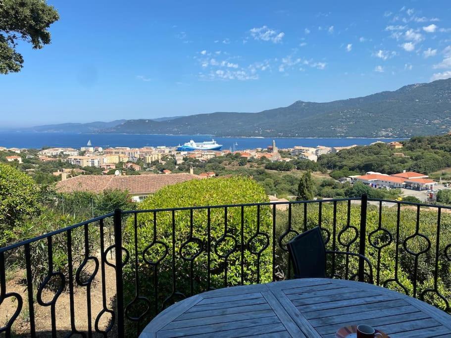 a balcony with a table and a view of the water at Maison Conviviale, Vue Mer in Propriano