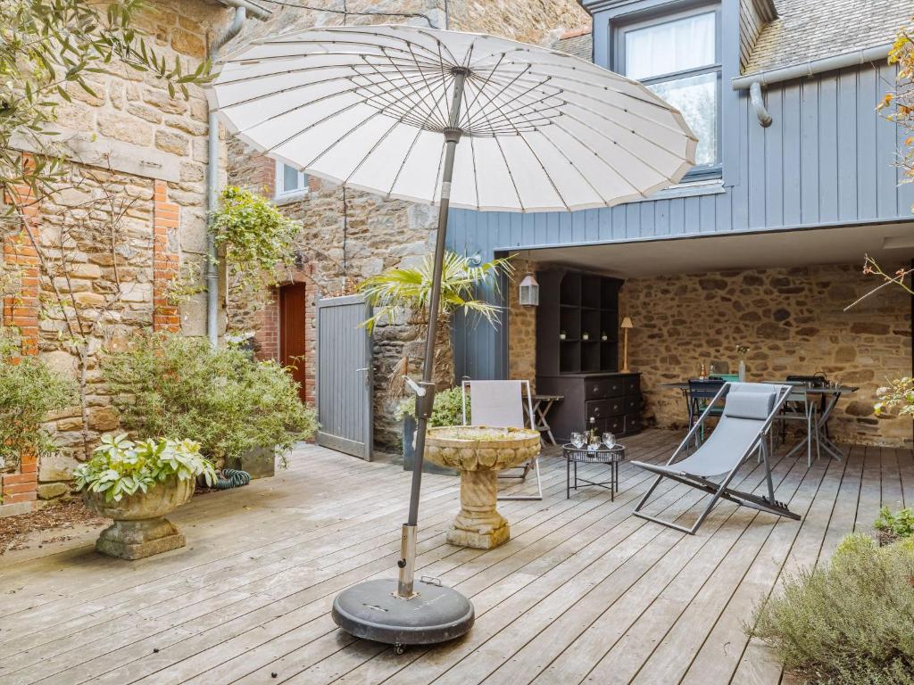 eine Terrasse mit einem Sonnenschirm auf einer Holzterrasse in der Unterkunft Villa Scarlette by Interhome in Saint-Briac-sur-Mer
