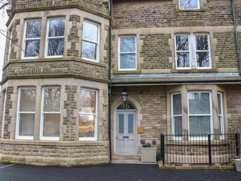 Casa de ladrillo con puerta blanca y ventanas en Hunter's Lodge, en Buxton