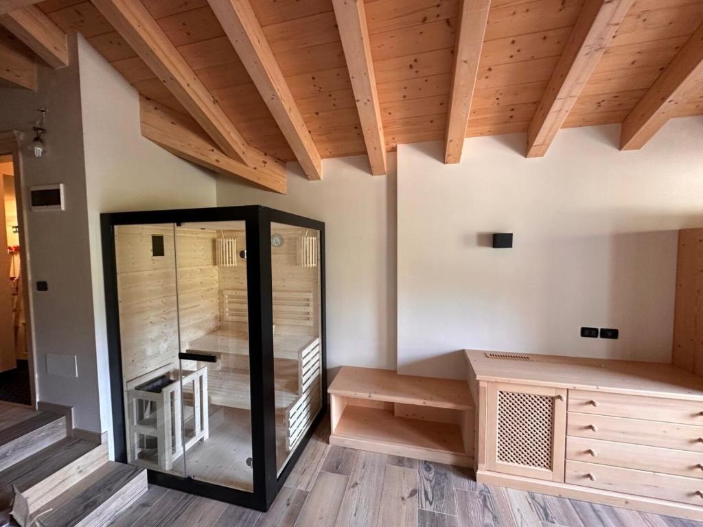 フィエーラ・ディ・プリミエーロにあるRifugio Caltenaのガラス張りのエレベーターと木製の天井が備わる客室です。