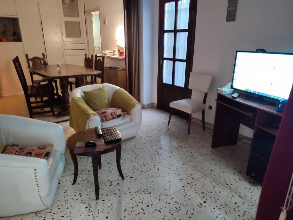 sala de estar con TV, silla y mesa en El Puente de SIl en Coronel Suárez
