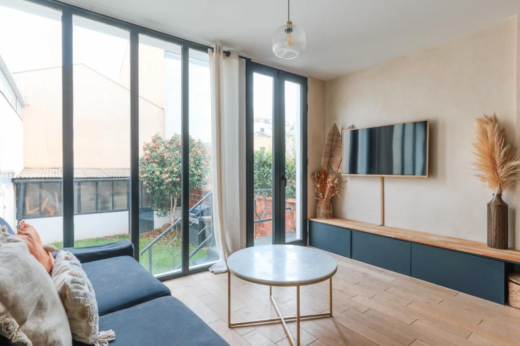 un salon avec un canapé bleu et une télévision dans l'établissement Bright two storey house - Quais de la Seine, à Asnières-sur-Seine