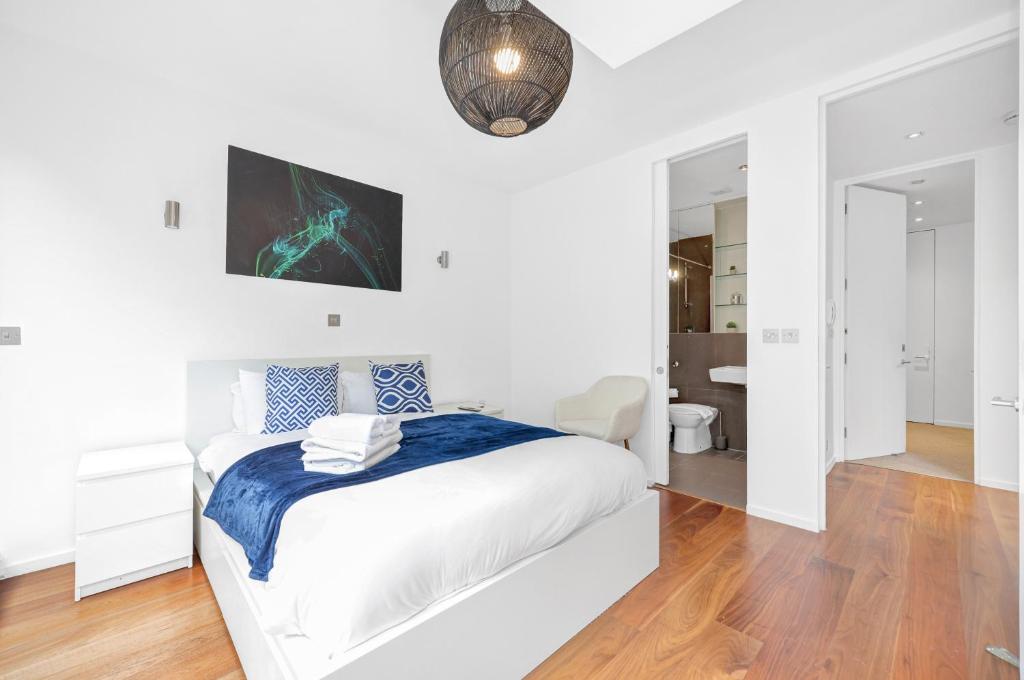 um quarto branco com uma cama e um espelho em Loft-style 3 bed apartment in Hoxton London! em Londres