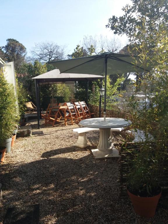 - une table de pique-nique avec un parasol dans le jardin dans l'établissement SAS CAMPING PARC MONTANA, à Gassin
