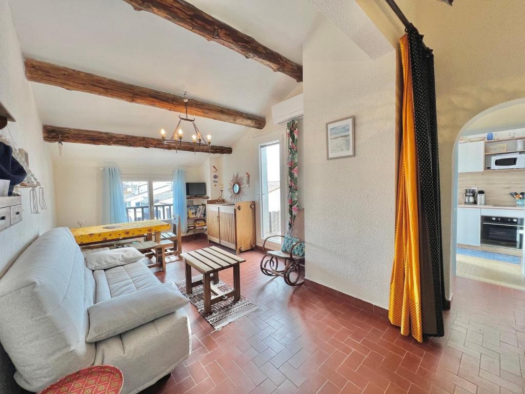 uma sala de estar com um sofá e uma mesa em Plage, centre ville, terrasse em Saintes-Maries-de-la-Mer
