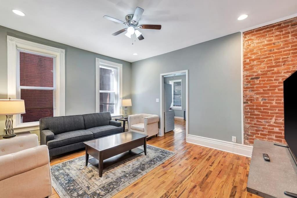 a living room with a couch and a brick wall at Central St Louis apartment 1W in Soulard