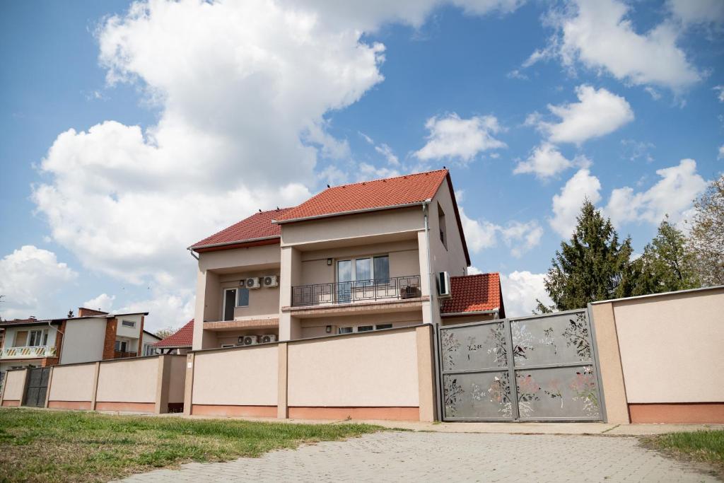 ein Haus mit einem Zaun davor in der Unterkunft Farkas Villa in Mórahalom