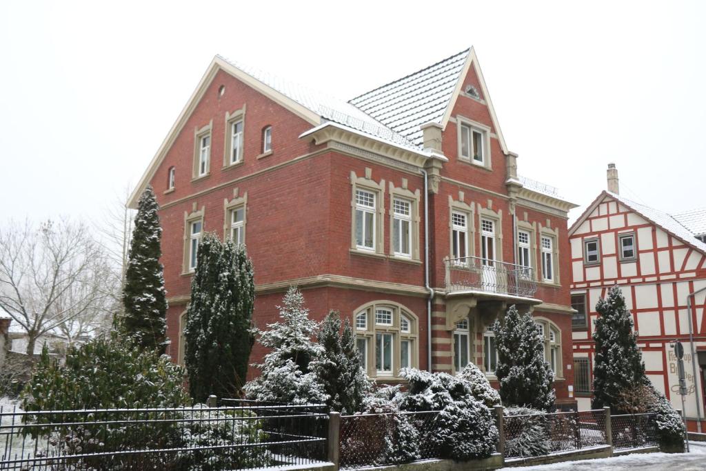 a large red brick house with snow on it at Ferienwohnung Mandelblüte in Schotten