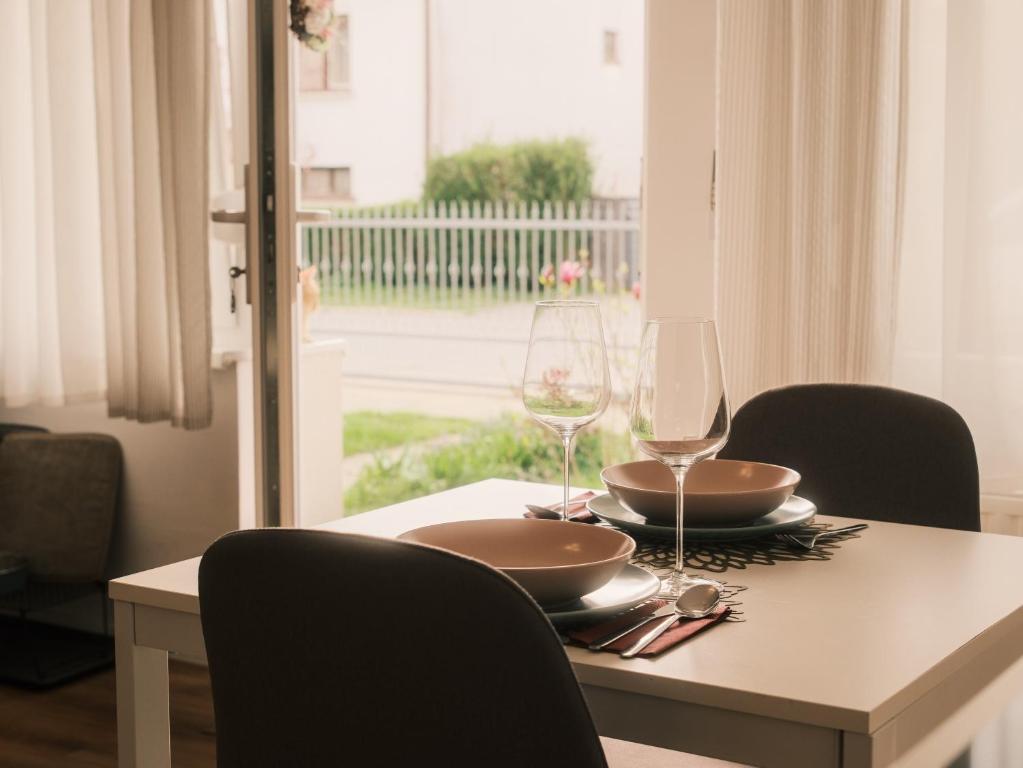 Studio apartmani Venium في Križevci: طاولة غرفة الطعام مع كأسين من النبيذ عليها