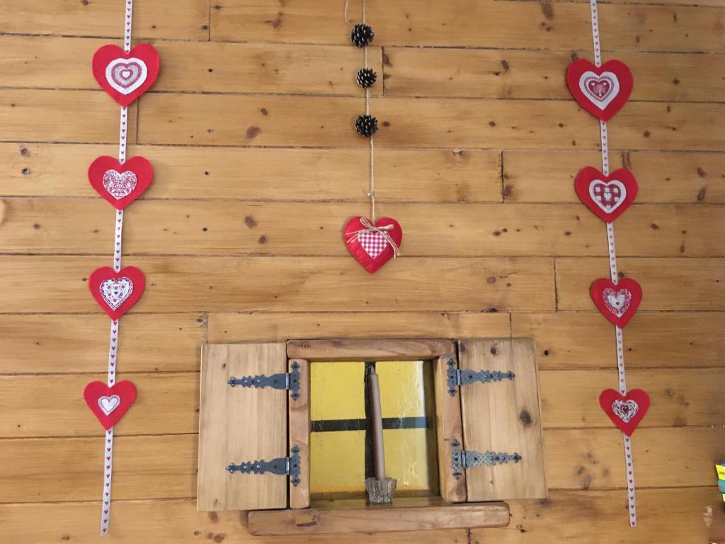 ein Zimmer mit Herzen an der Wand und einem Fenster in der Unterkunft La casa del bosco in Aosta