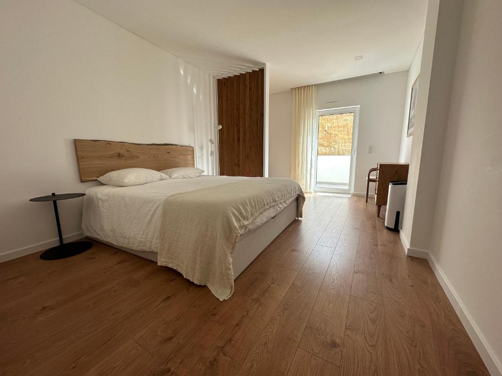 1 dormitorio con 1 cama y suelo de madera en Casa Aga- Cozy Seaside Apartment en Ericeira
