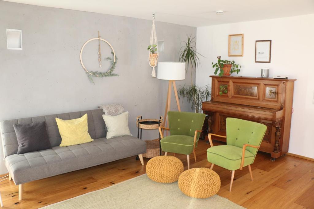 uma sala de estar com um sofá e cadeiras e um piano em Sonnennest em Hirschegg