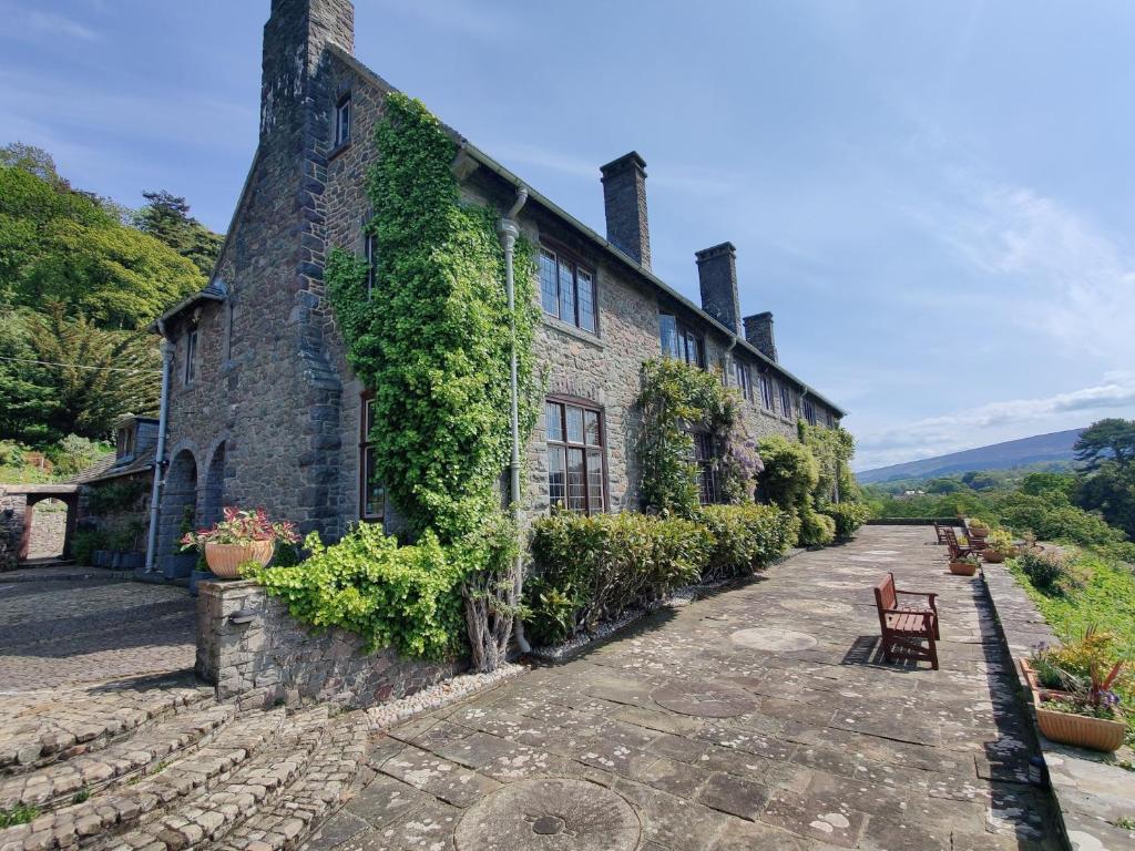 a stone house with ivy on the side of it at Luxury Bed And Breakfast at Bossington Hall in Exmoor, Somerset in Porlock