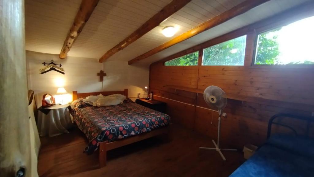 維多利亞的住宿－El Respiro，卧室配有一张床铺,位于带木墙的房间内