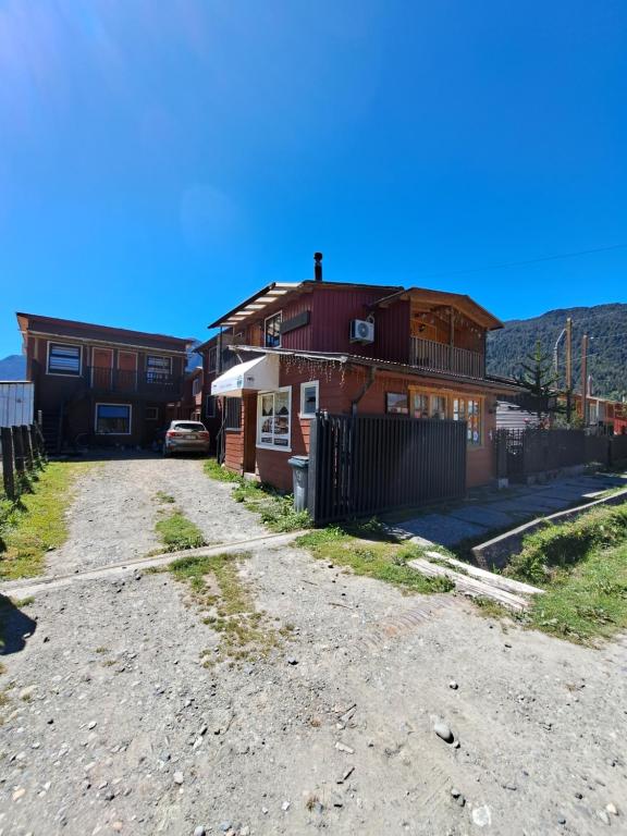 a couple of buildings on a dirt road at Hostal Robinson in Puerto Puyuhuapi