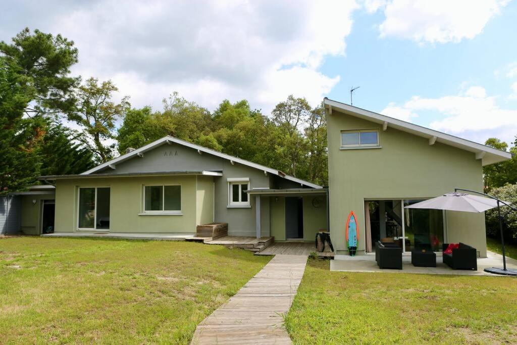 une maison avec un parasol dans une cour dans l'établissement Très belle Villa - Plage à pied, à Labenne