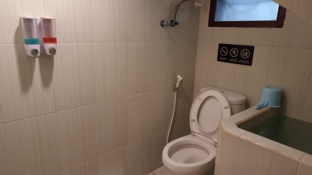 a bathroom with a toilet and a bath tub at Villa Estate 43 New in Batu