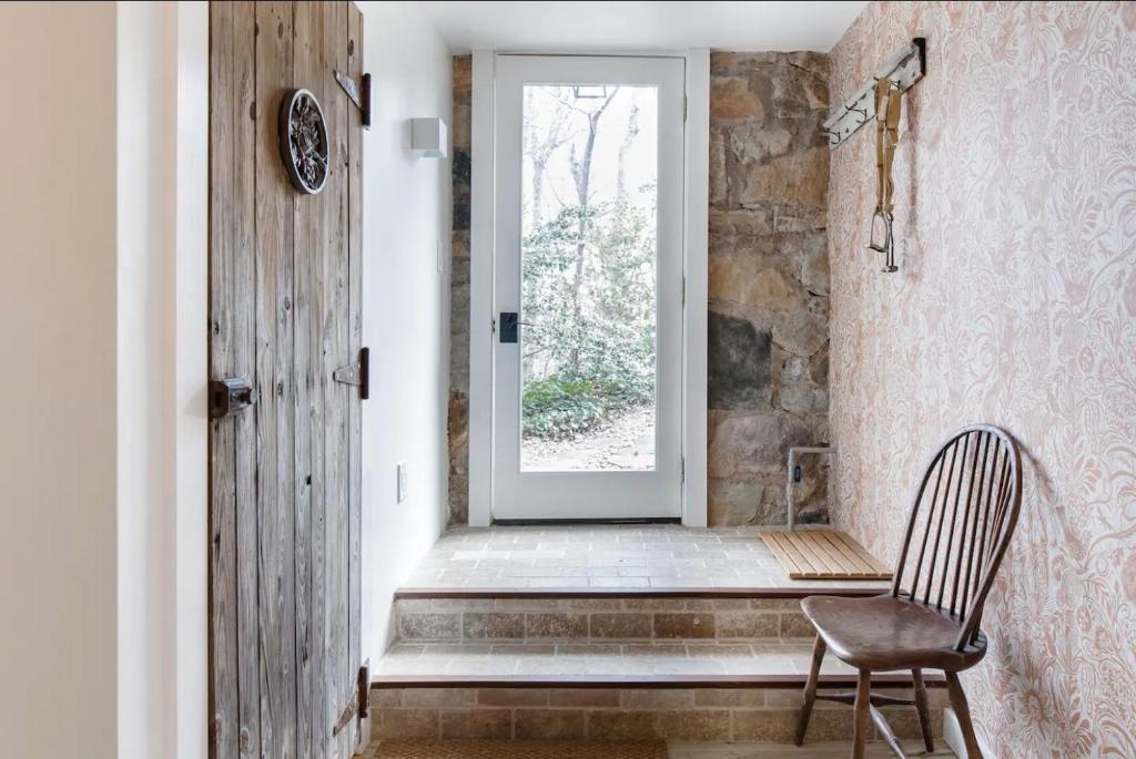 une porte avec une chaise en face d'une fenêtre dans l'établissement Studio Guest Suite in Forest Cottage, à Tryon