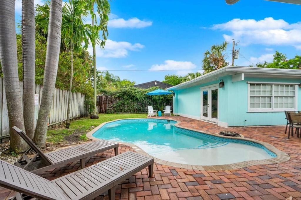 een zwembad met twee stoelen en een huis bij Zach's Tropical Pool House in Fort Lauderdale