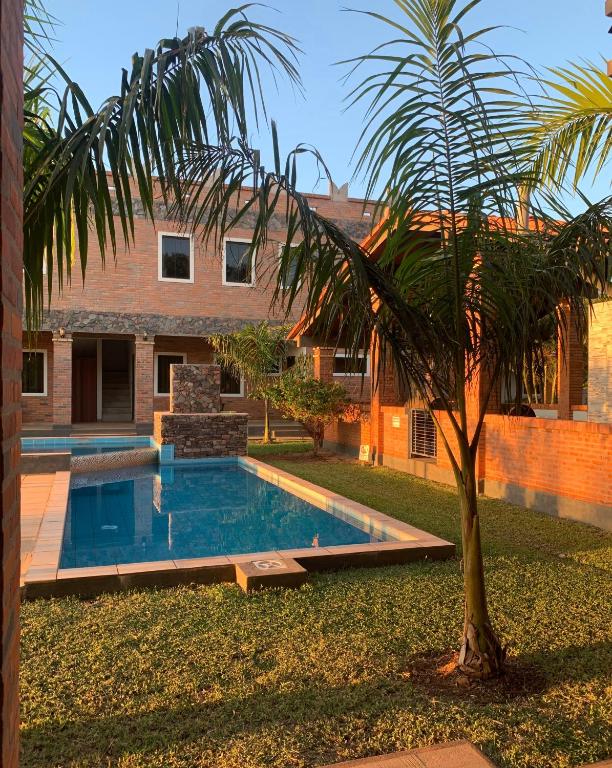a palm tree in front of a house with a swimming pool at Hotel Il Castello in Villa Concepción