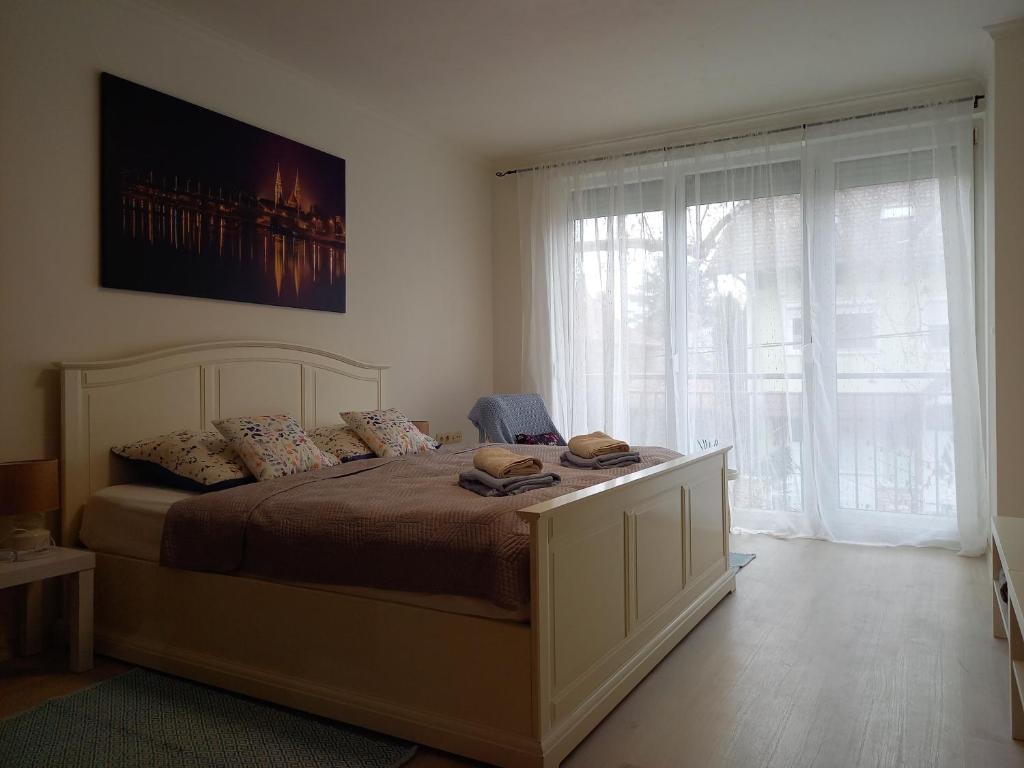 a bedroom with a bed and a large window at Mimi Apartman in Szeged