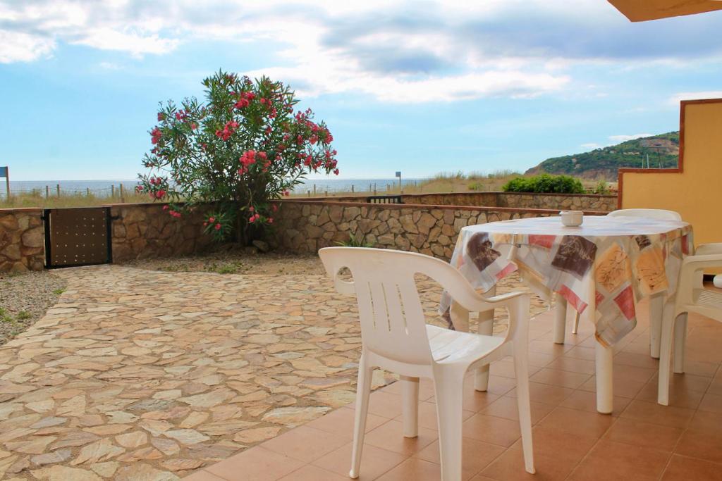 einen weißen Tisch und Stühle auf einer Terrasse in der Unterkunft Les Dunes Vista al mar frontal 3H 315 in Begur