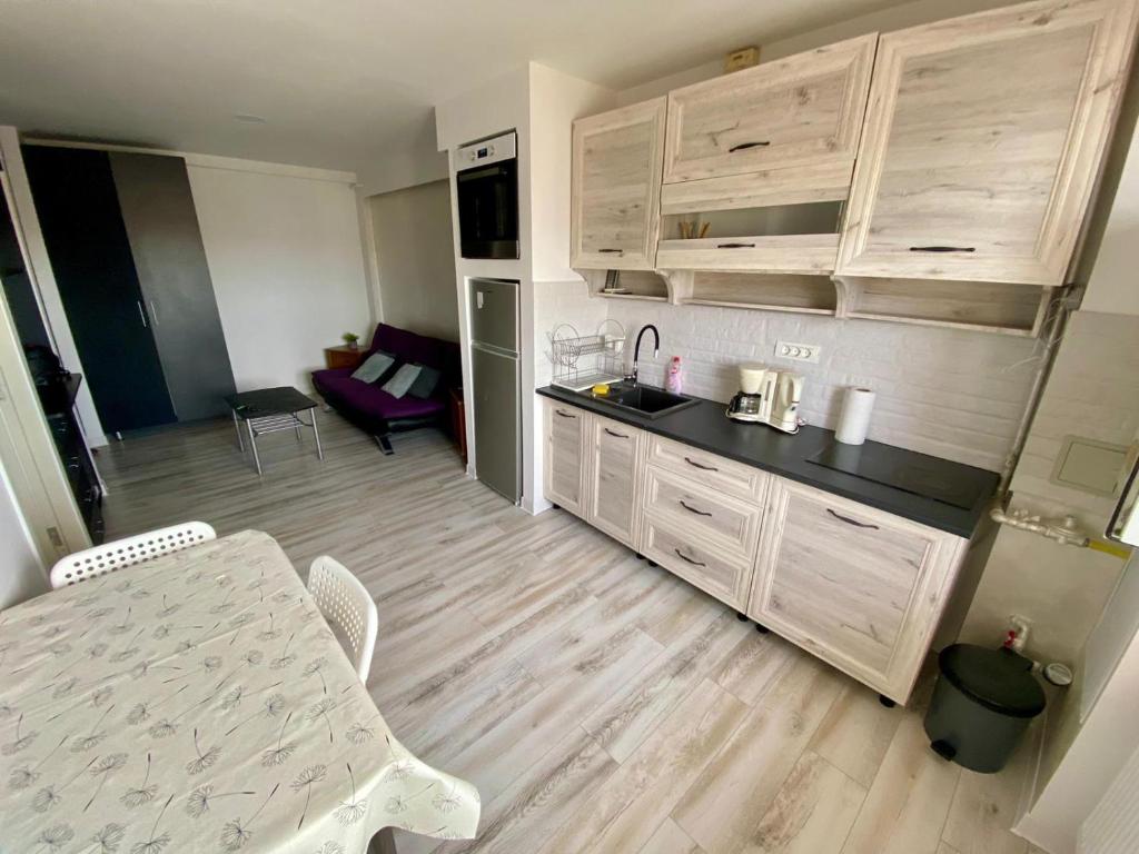 - une cuisine avec des placards blancs, une table et des chaises dans l'établissement Like Home, à Arad