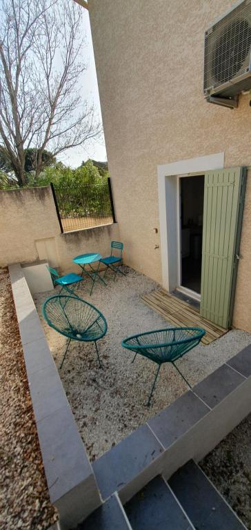 deux tables et chaises devant un bâtiment dans l'établissement 1 studio RDC et 1 studio 1er étage hauts de villeneuve les Avignon, à Villeneuve-lès-Avignon