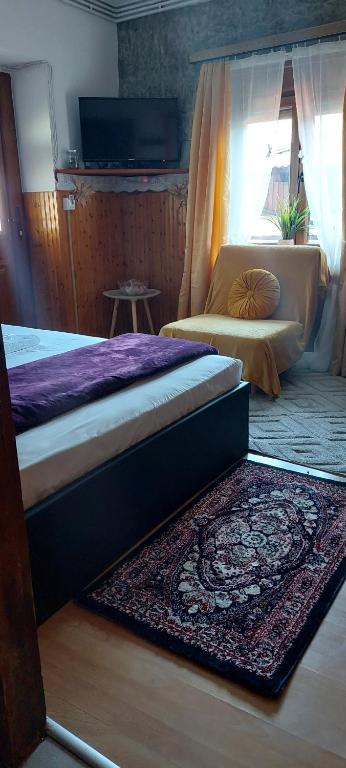 a bedroom with two beds and a rug on the floor at ΔΙΑΜΕΡΙΣΜΑ ΧΩΡΗΤΙΚΟΤΗΤΑΣ ΜΕΧΡΙ 4 ΑΤΟΜΩΝ ΚΕΝΤΡΙΚΑ! in Metsovo