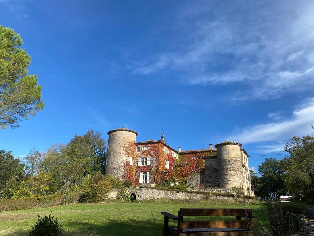 a building with three towers on top of a field at Chateau de Montcuquet in Lautrec