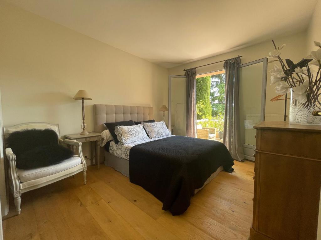 una camera con un letto e una sedia e una finestra di Carolienne a Vallauris