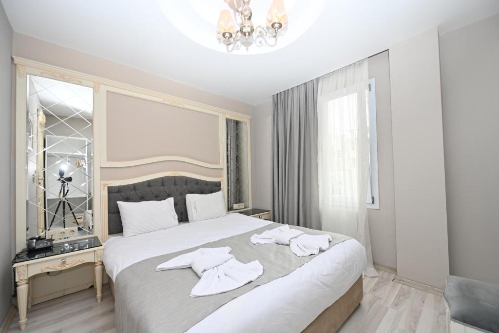 1 dormitorio con 1 cama grande y toallas. en Albatros İstanbul en Estambul