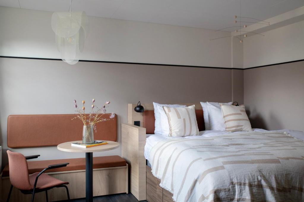 um quarto com uma cama, uma mesa e uma cadeira em Bob W Østerbro Copenhagen em Copenhaga