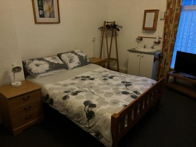 a bedroom with a bed and a table and a sink at Argyll guest house in Blackpool