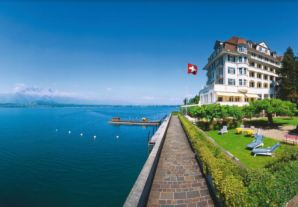 un gran edificio junto a una gran masa de agua en Hotel Restaurant Bellevue au Lac en Thun