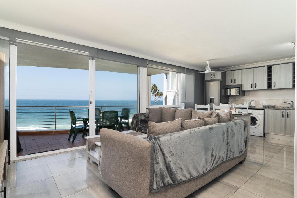 a living room with a couch and a view of the ocean at Chakas Cove 38 in Ballito