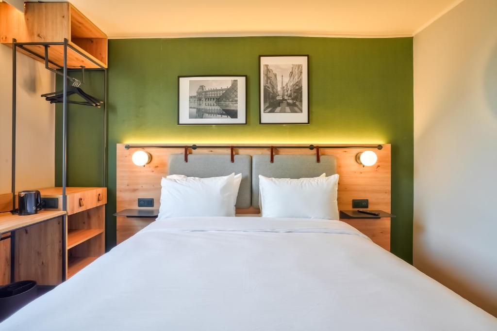 a bedroom with a large bed with a green wall at Campanile Paris Ouest - Pont de Suresnes in Suresnes