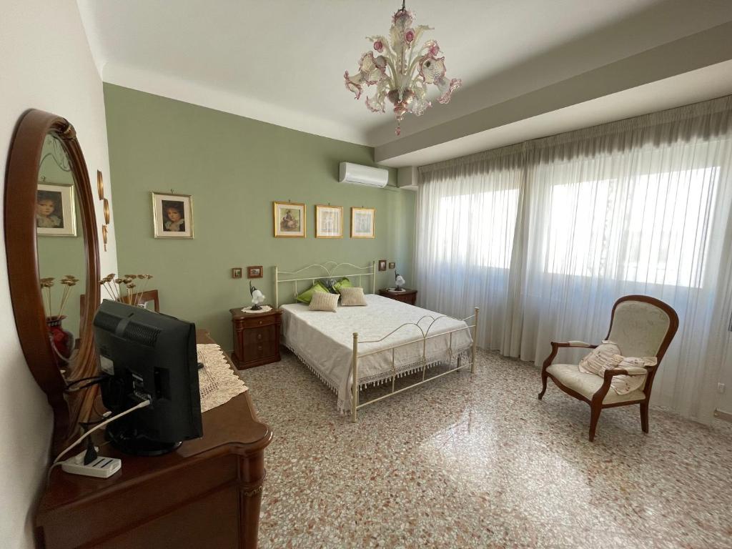 a bedroom with a bed and a tv and a chair at Dimora Cadò Alloggio Turistico Privato in Taranto