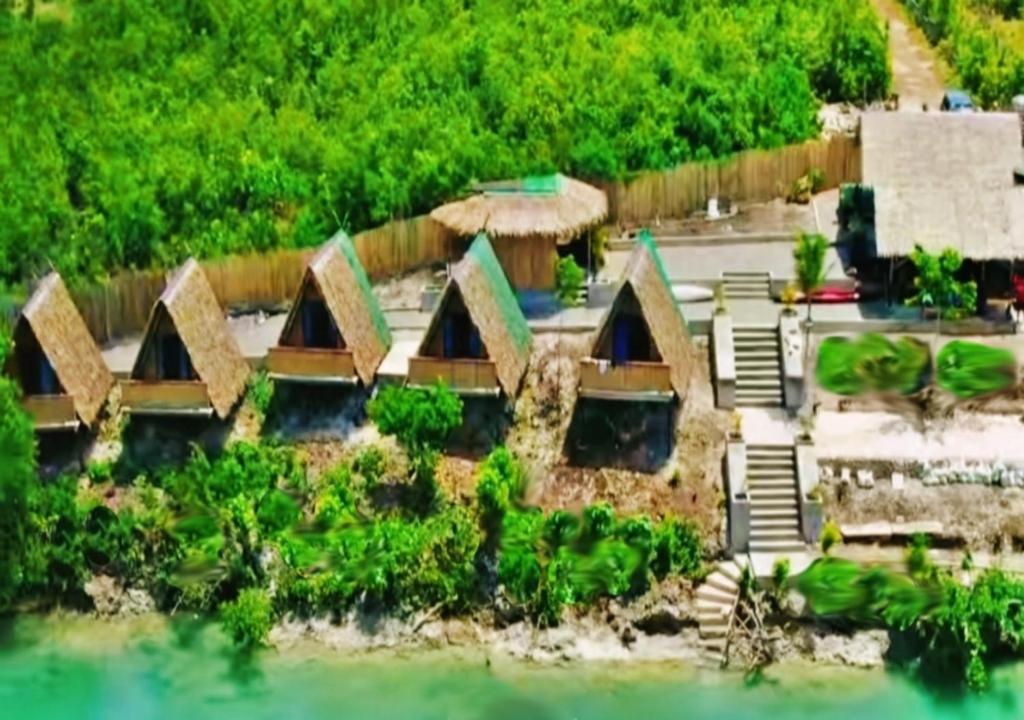 an aerial view of a house on the water at Riu del Mar Hostel in Dauis