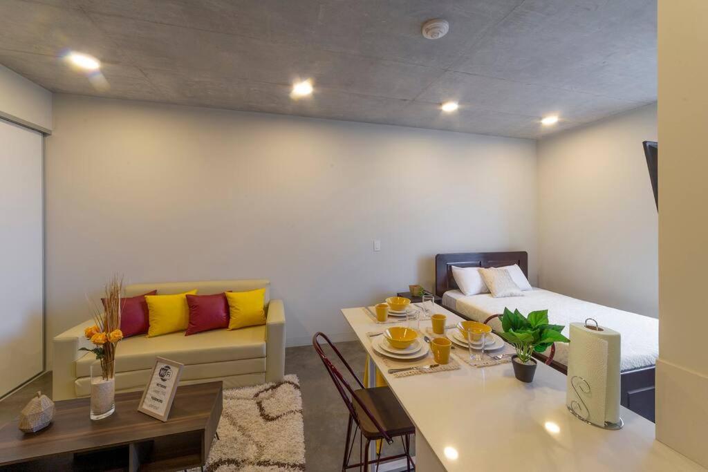 a room with a bed and a table and a bed and a bedroom at 2512 URBN Escalante Hermoso Loft SIN PARQUEO in San José