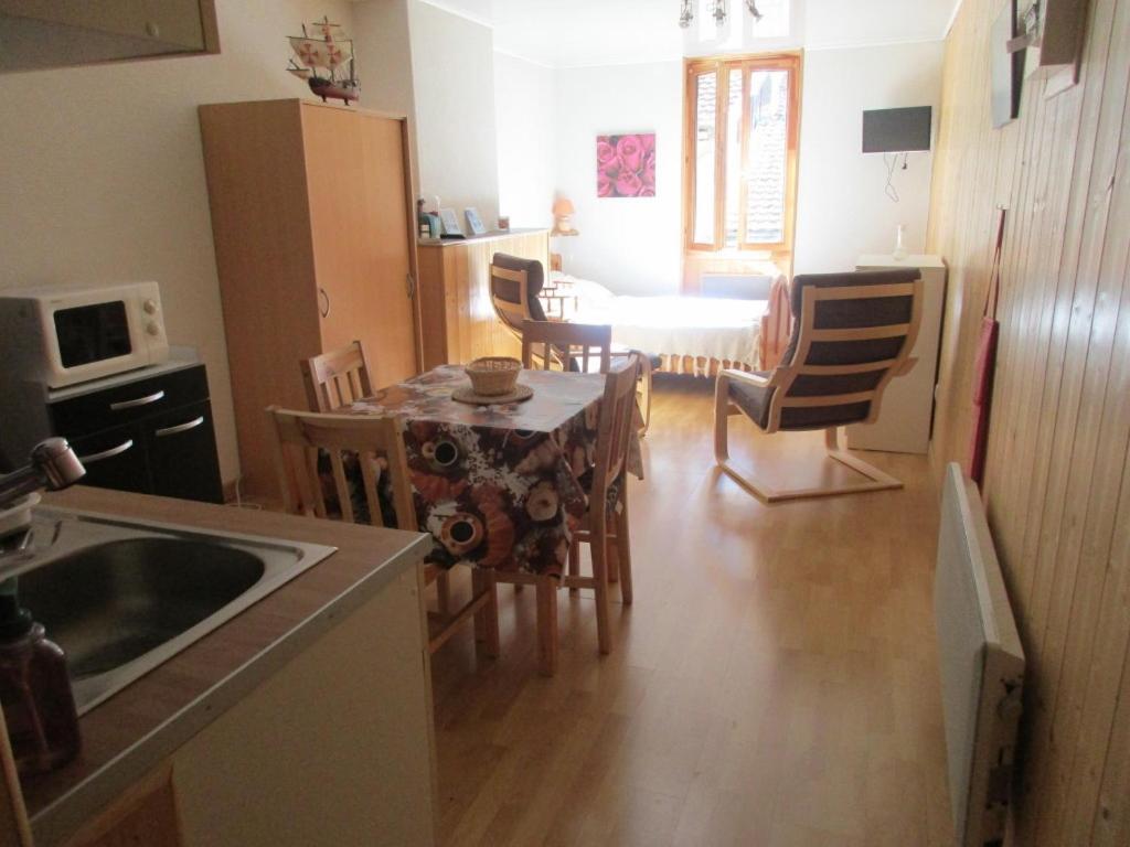 a kitchen and dining room with a table and chairs at Au P'tit Grillon in Salins-les-Bains