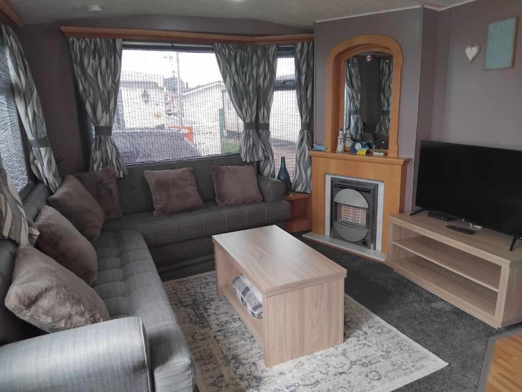 a living room with a couch and a tv at Sunnyside - Pet friendly, Ingoldmells in Ingoldmells