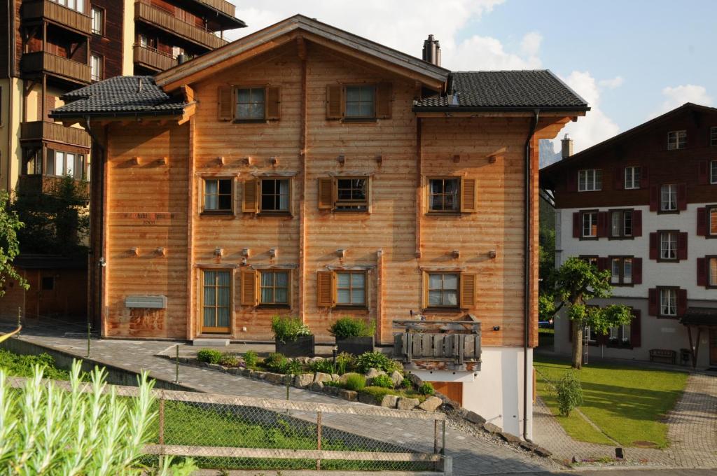 a large wooden house with a roof at Chalet Alpina Gyger in Wengen