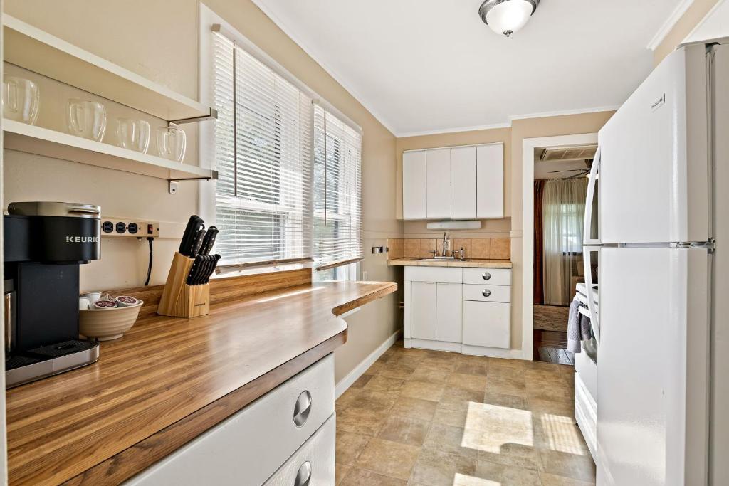 a kitchen with white cabinets and a white refrigerator at Vintage View Loft in St. Petersburg