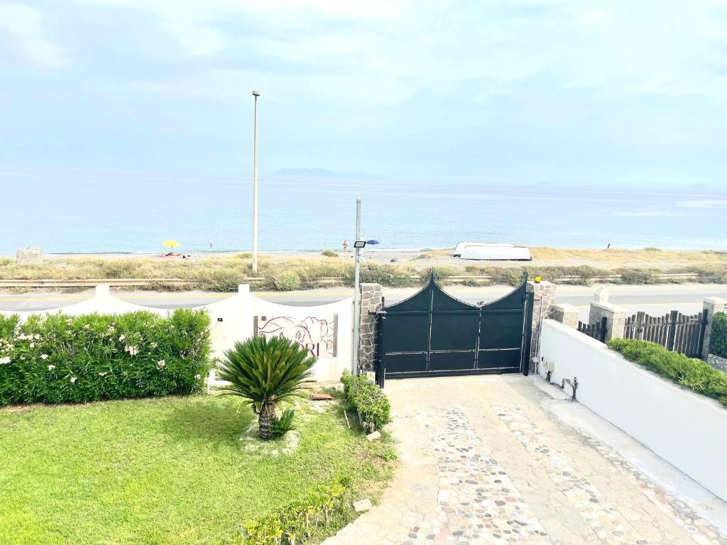 um portão para uma casa com a praia ao fundo em B&B I 3 Mori em Barcellona-Pozzo di Gotto
